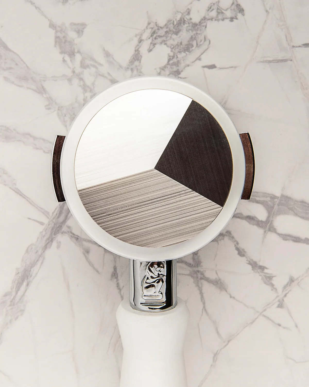 Round espresso tamper with a three-tone wood inlay top, shot from above on white marble