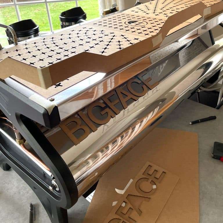 Custom BIGFACE cup tray panel and machine parts with printed BIGFACE packaging in the Artpresso workshop