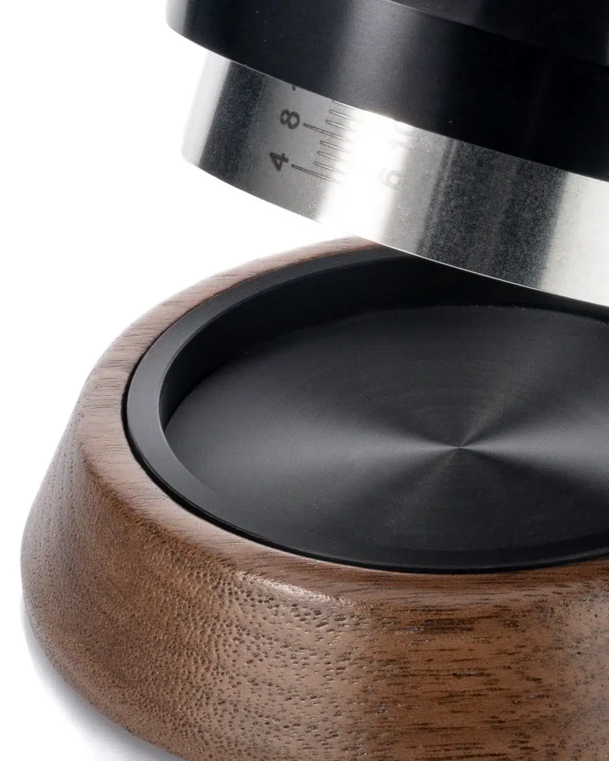 La Marzocco tamper lifted from its walnut and black stand