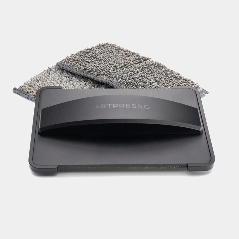 Drain Tray Pro Cleaning Tool in black anodized aluminum, resting on its microfiber pad