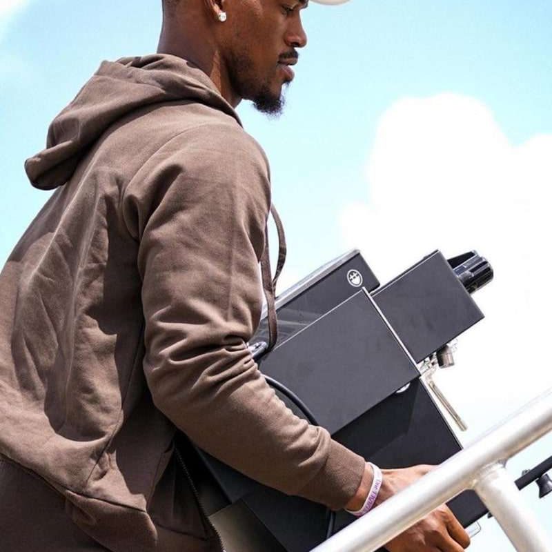 Jimmy Butler carrying his BIGFACE La Marzocco Linea Mini espresso machine outdoors