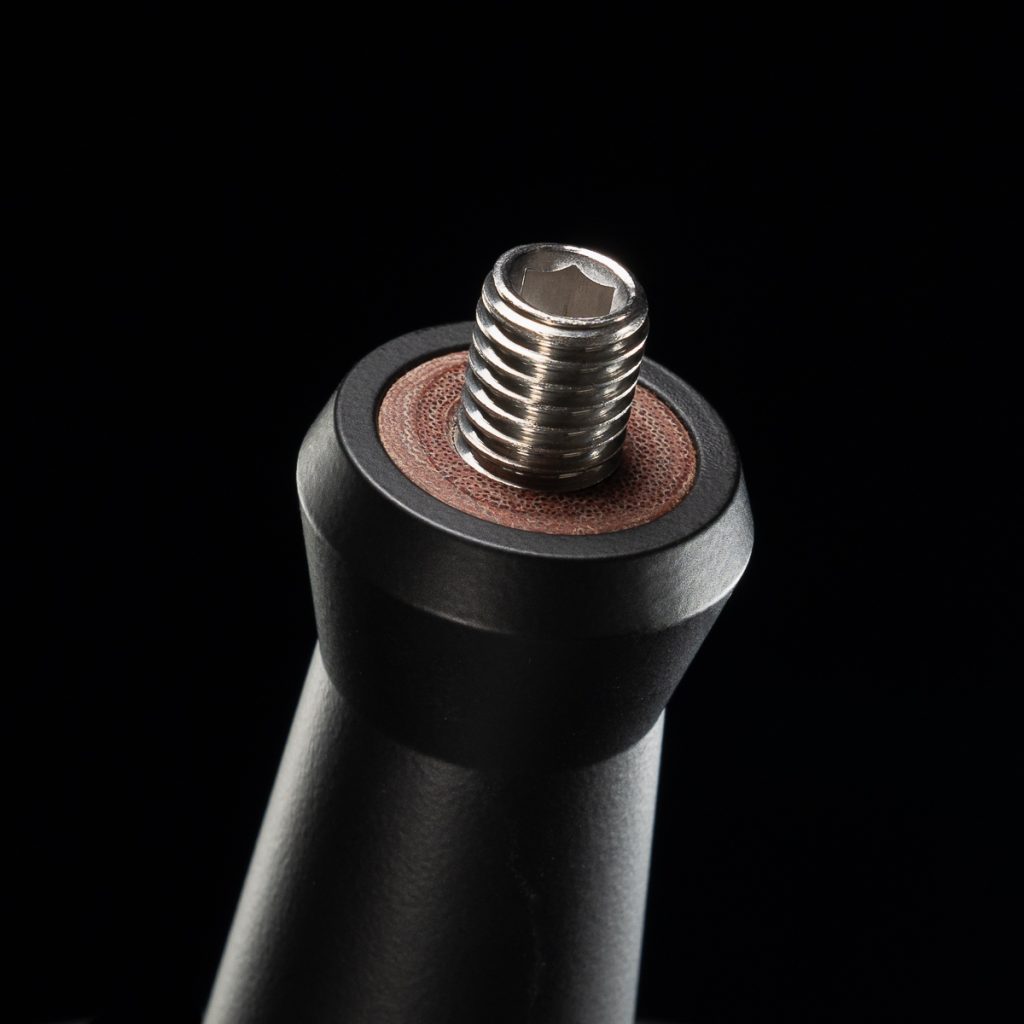 Close detail of the stainless threaded stud rising from the insulated core set into the end of a black portafilter handle, which keeps the heat of the portafilter out of the handle