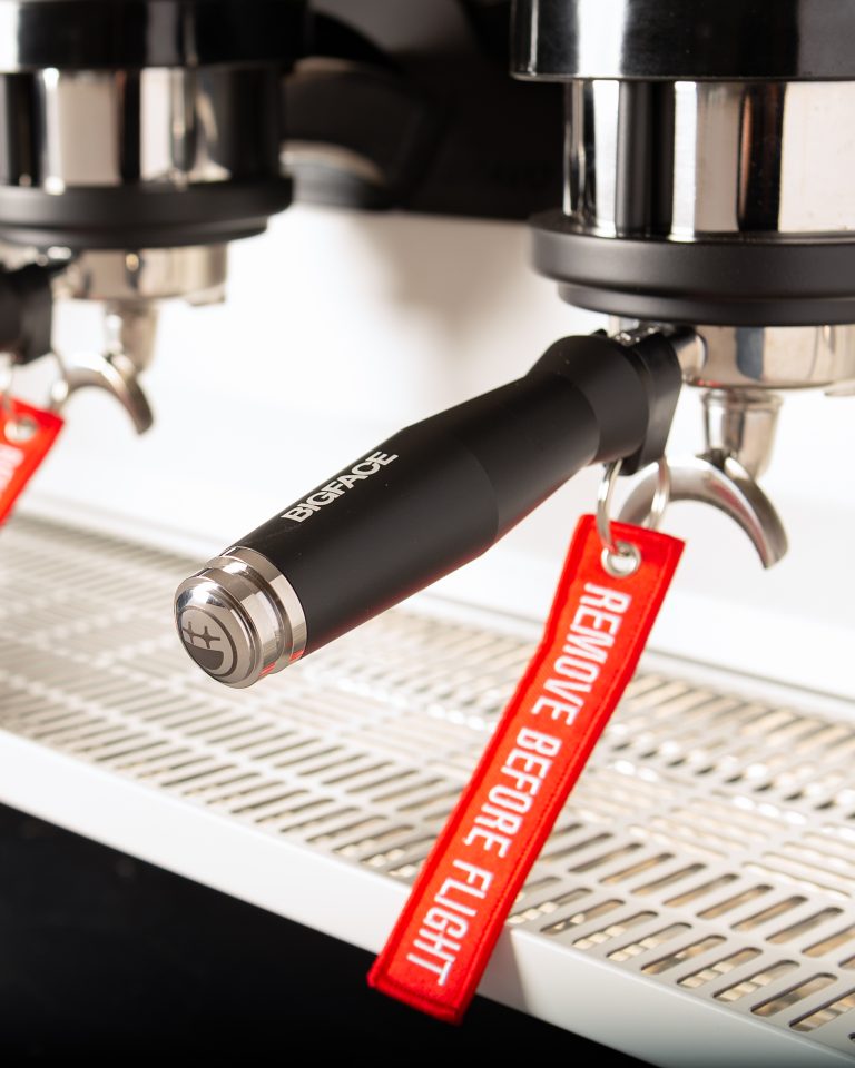 BIGFACE portafilter in the group with a red Remove Before Flight tag attached