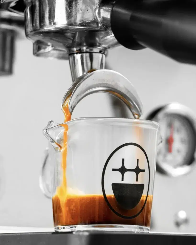 Espresso pouring into the BIGFACE glass shot pitcher under the group head