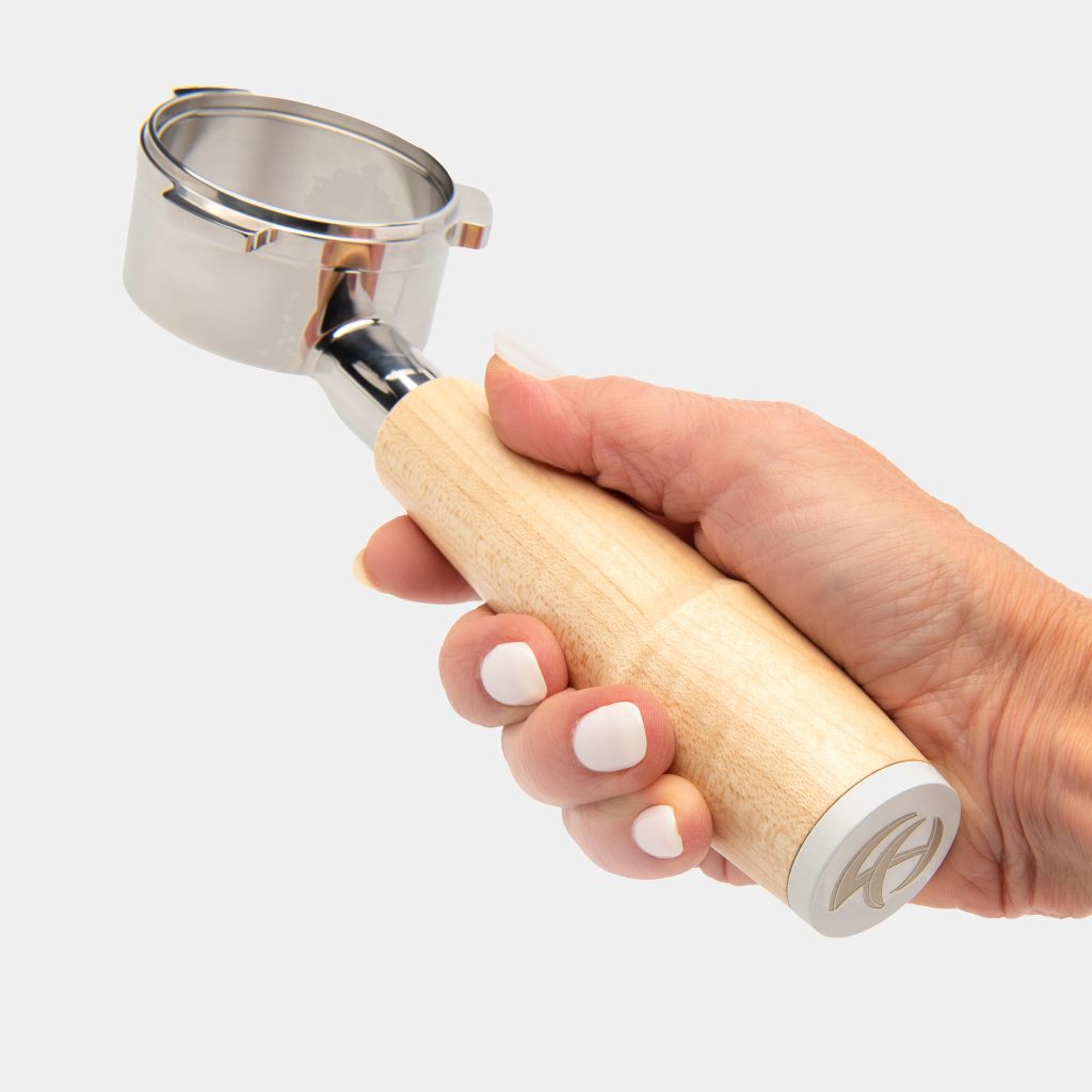 Hand gripping the maple handled Breville bottomless 54mm portafilter