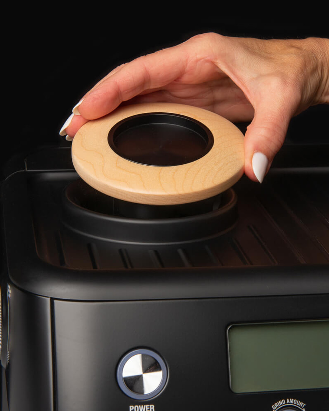 Hand placing the maple Artpresso tamper holder into the top of a Breville espresso machine