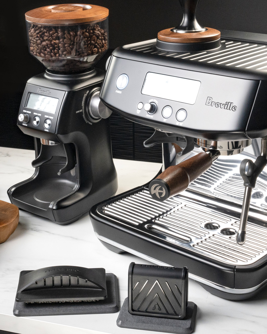 Artpresso steam wand and drain tray cleaning tools on their platforms in front of a Breville espresso machine and grinder